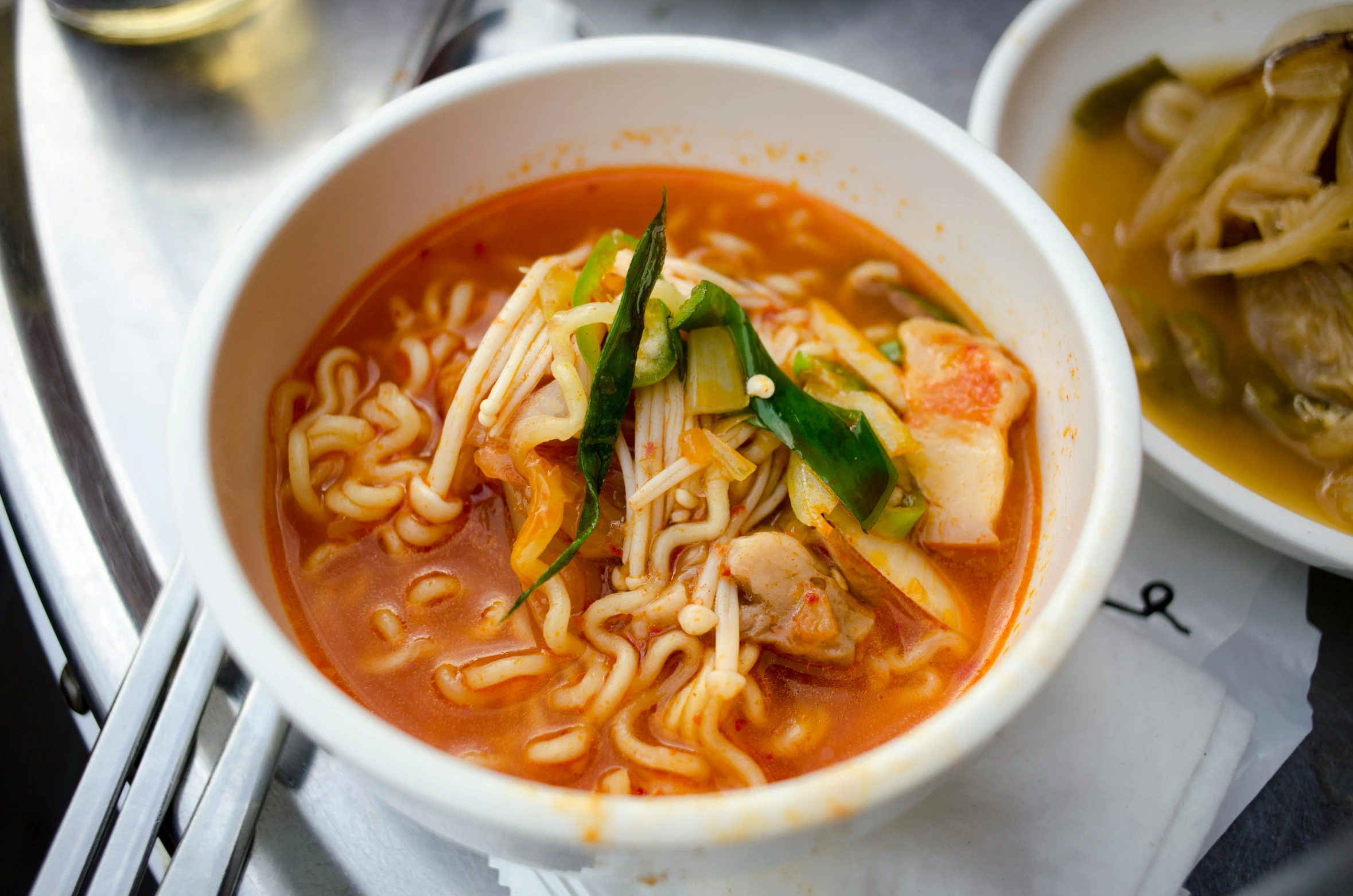 a white bowl full of noodles and vegetables