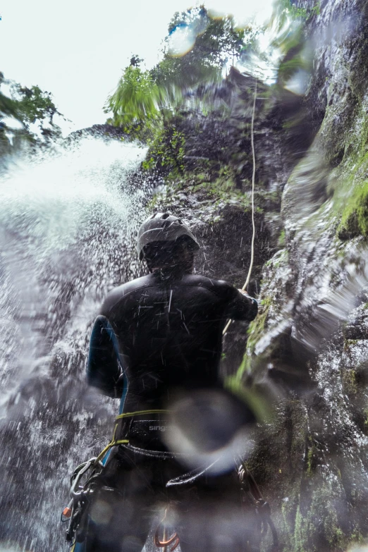 a man who is walking in the water with some plants