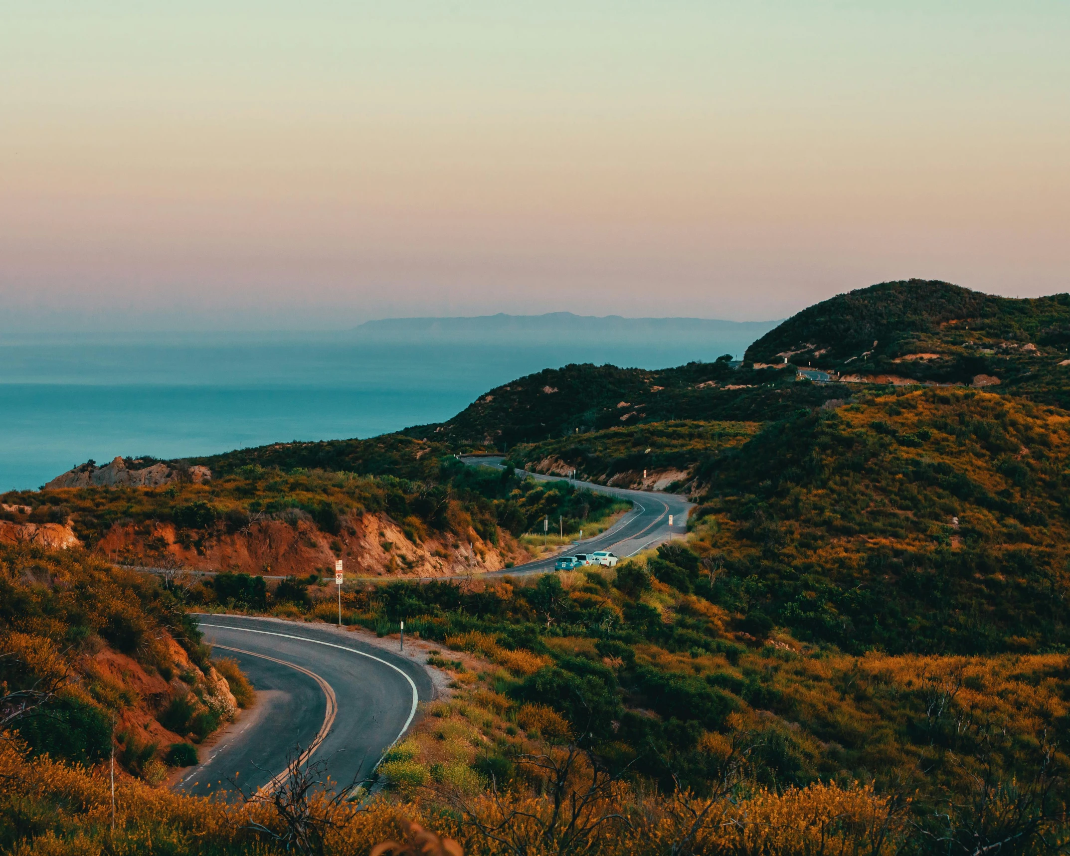 a road curves near the ocean in a scenic location