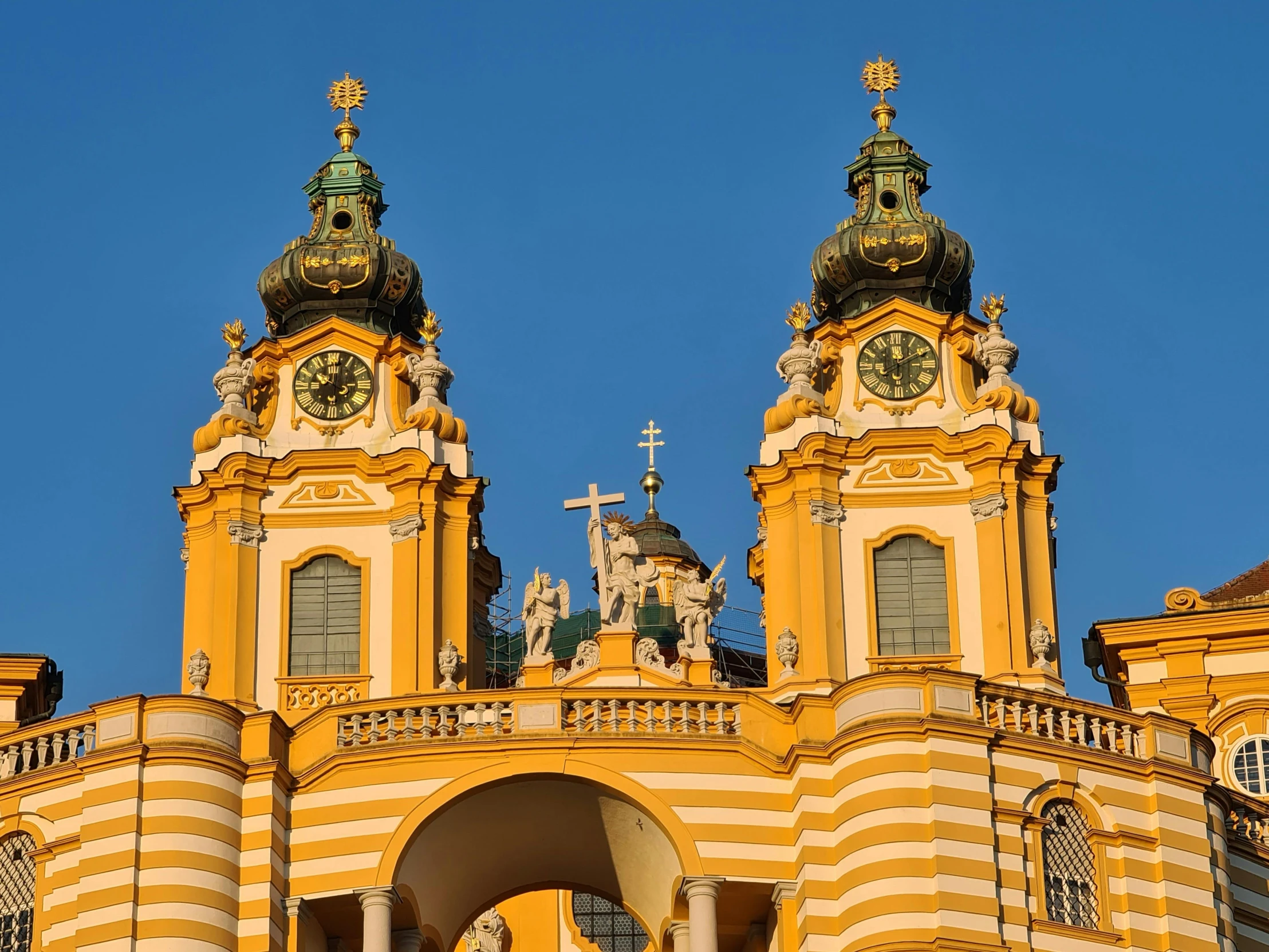 two towers with clocks and a cross in them