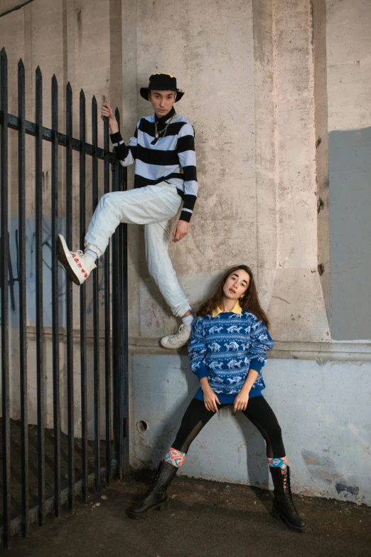 a couple of people sitting on top of a gate