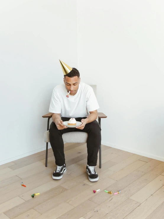 a man is sitting in a chair with a cake