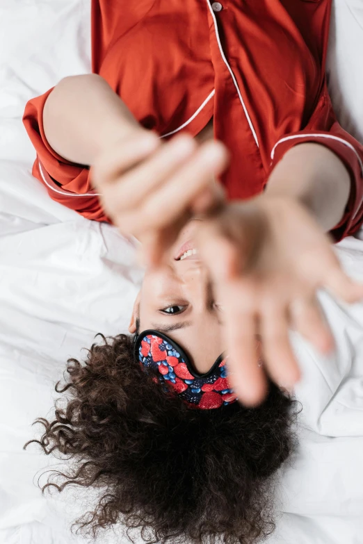 there is a woman that is lying on the bed with her head covered