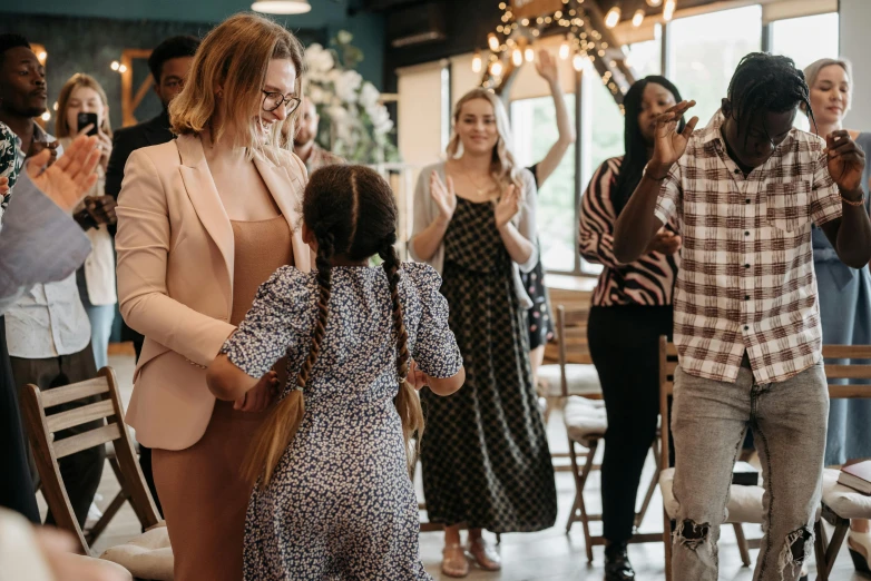 a woman and little girl standing in a room next to a party