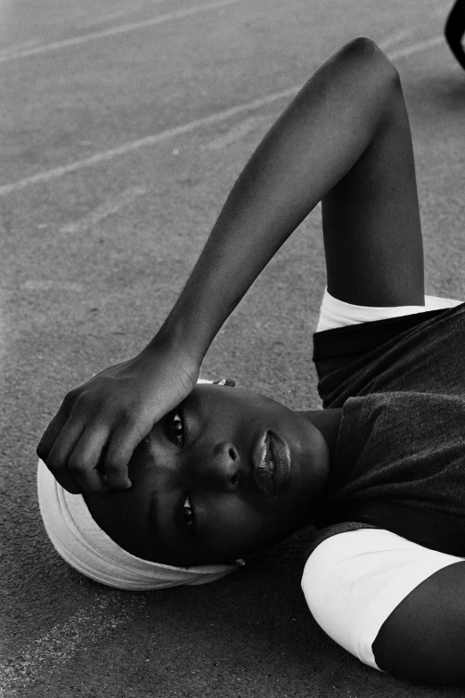 a boy is laying on his back in the street