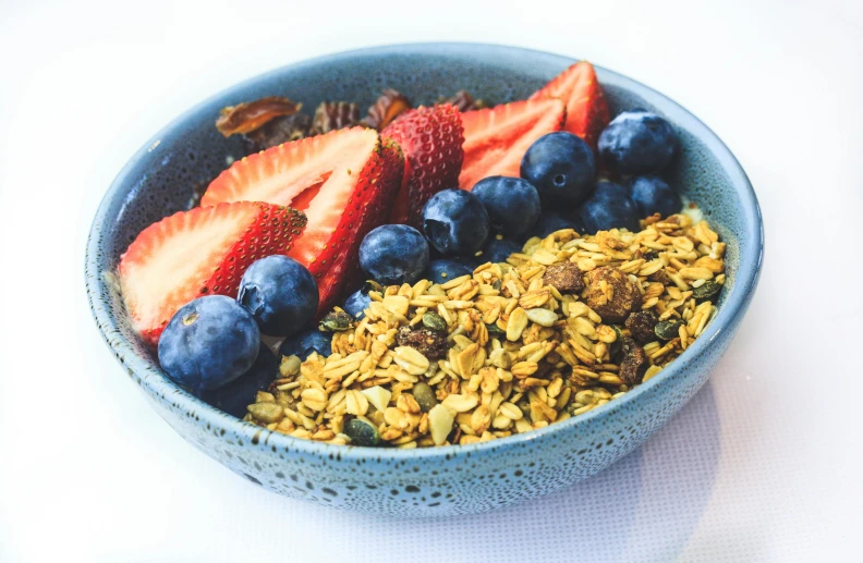 a bowl filled with granola, fruit and nuts