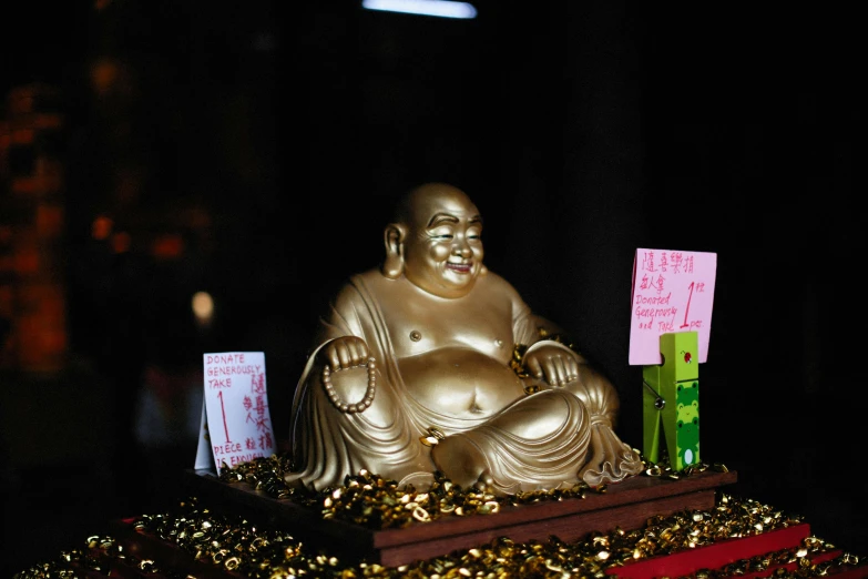 a large golden buddha statue sitting on top of a pile of gold coins