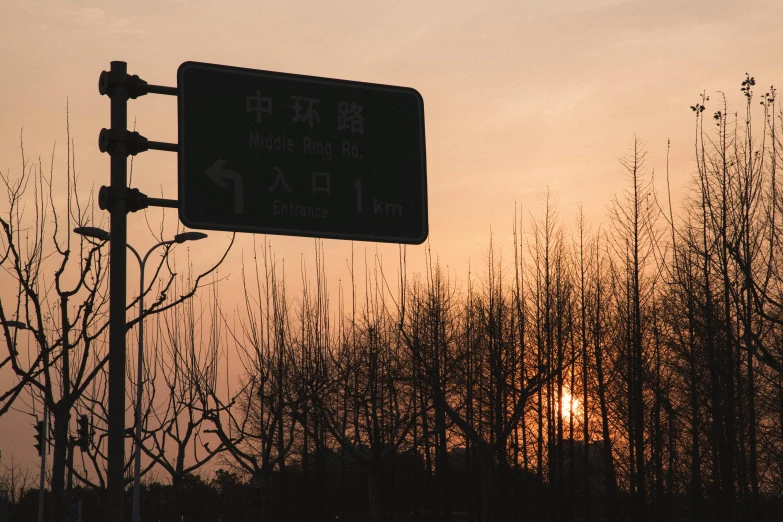 the street sign is shown with the sun setting in the background