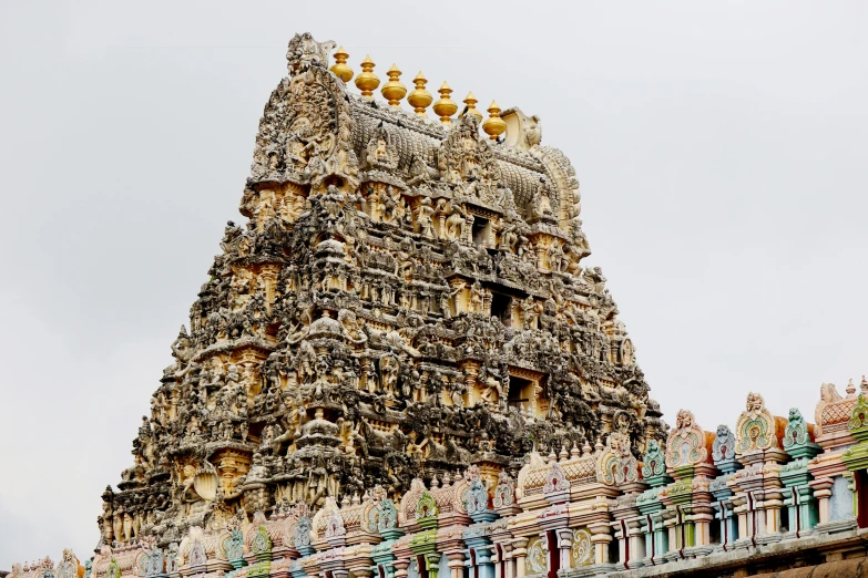 an ornate tower with sculptures and bird heads on top