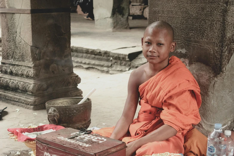 monk sitting in doorway with food and drink