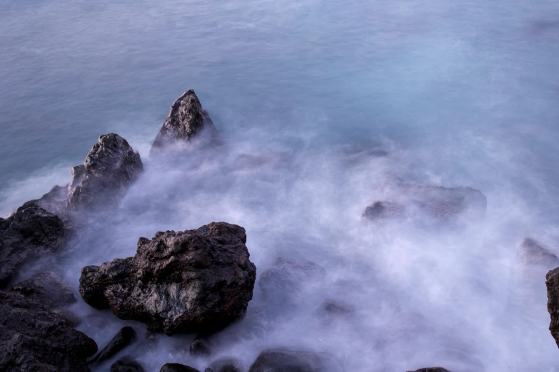 an ocean scene with rocks under water