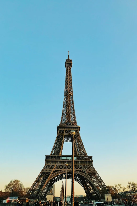 some people standing by a small statue in front of the eiffel tower