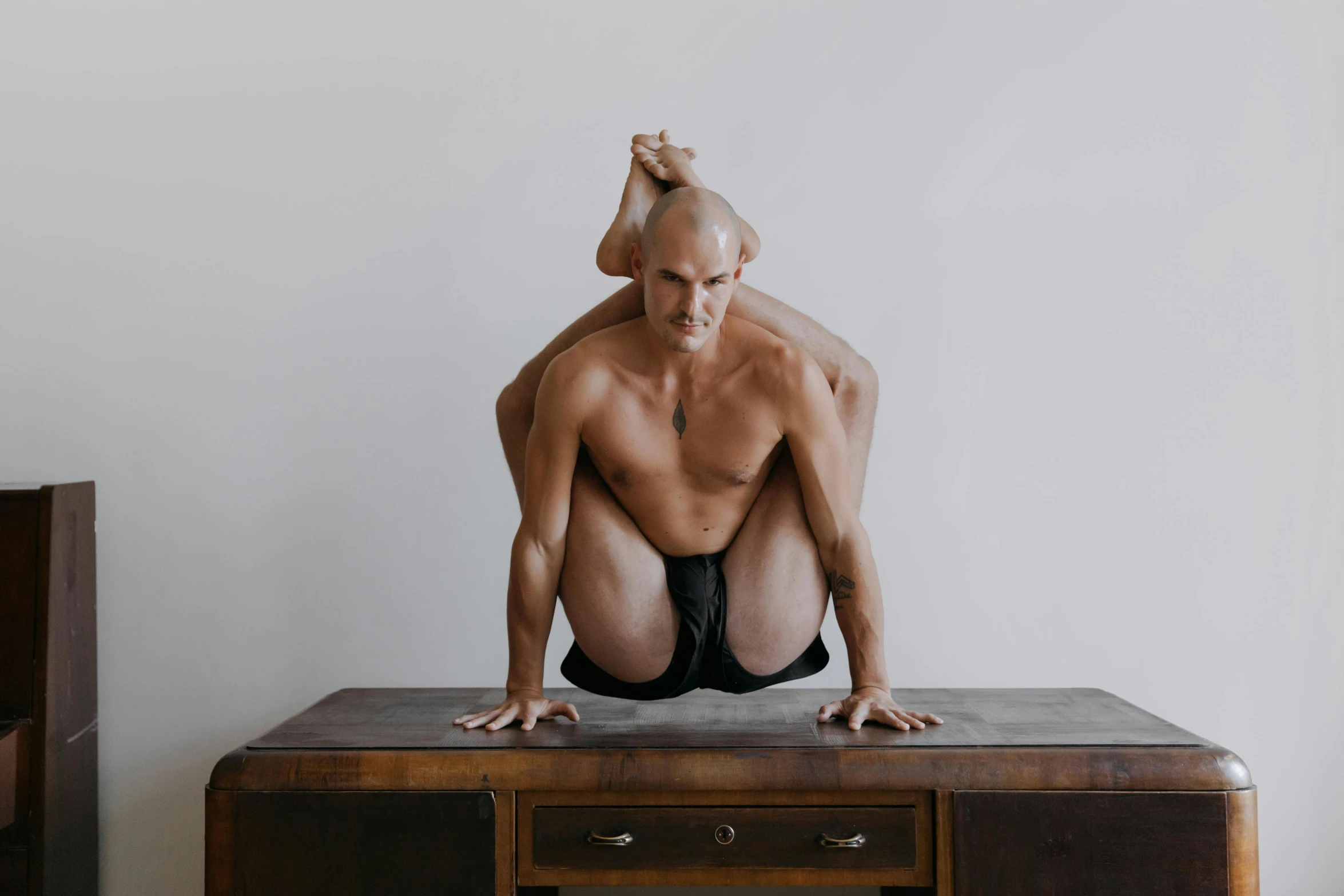 a man bent over and standing on top of a desk