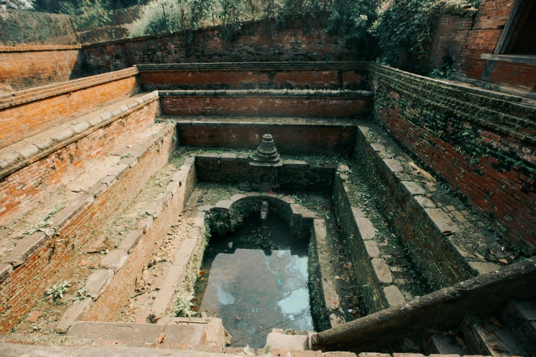 an open well with a stone floor and side stairs