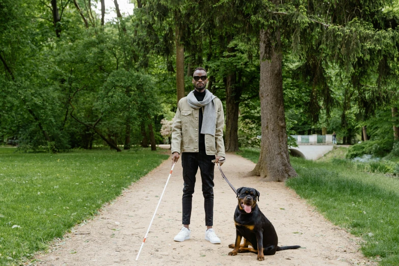 a man and his dog holding their leashes on the street