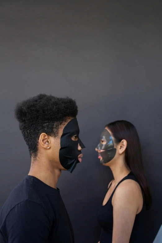 a couple has their face painted black with makeup