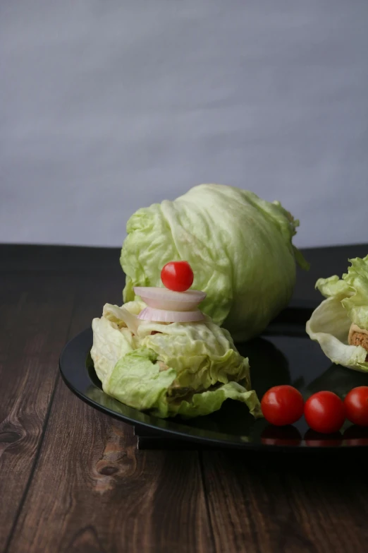lettuce and cherry tomatoes sit on a black plate