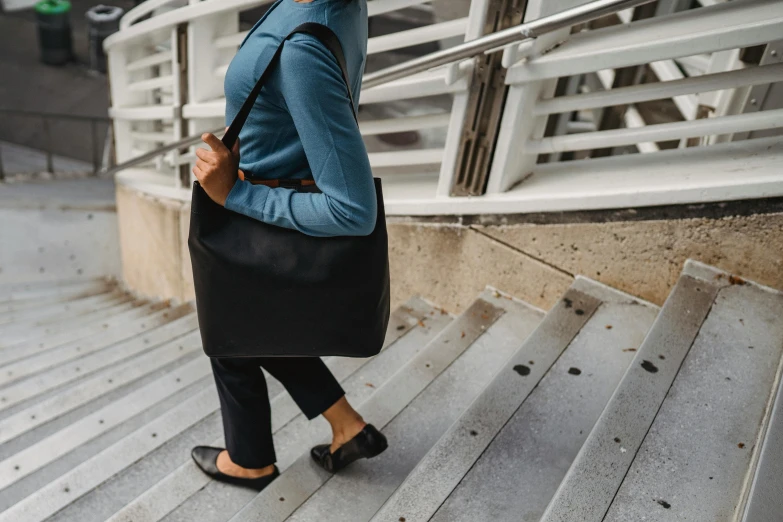 a women who is walking down the stairs carrying her purse