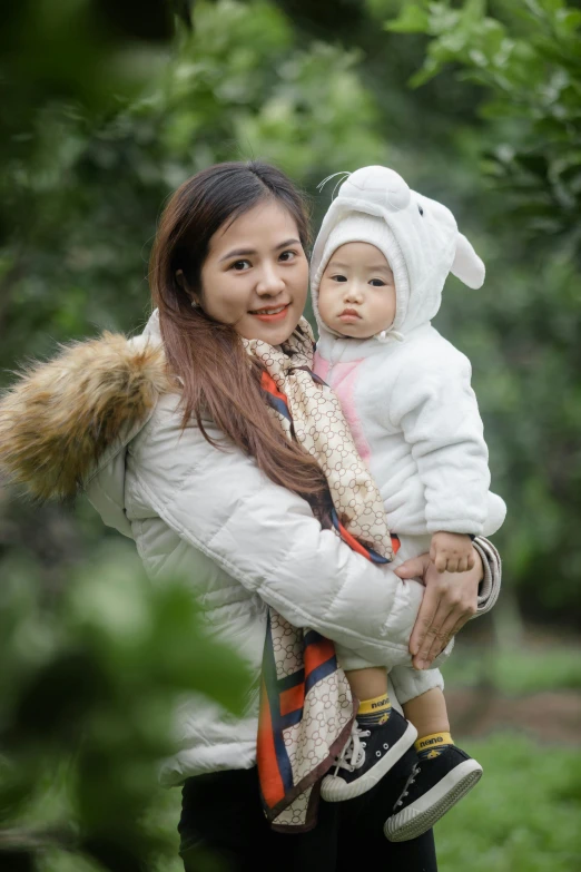 woman carrying baby wearing a hat with an animal on it