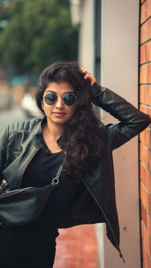 young woman with black hair and black glasses walking on sidewalk