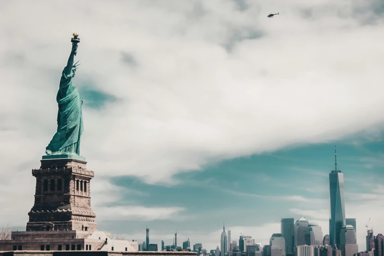 an airplane flying over the statue of liberty, new york