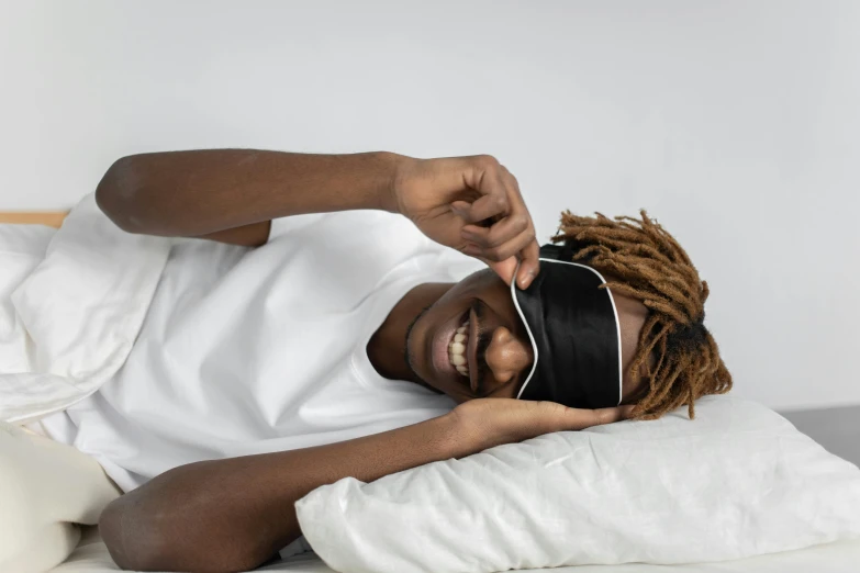 a man with blindfolded headband laying on pillow