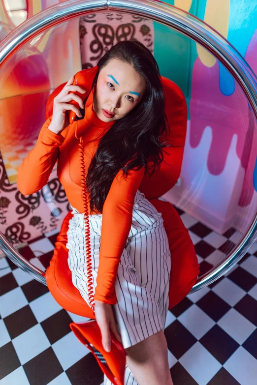 a woman sitting down in an orange top