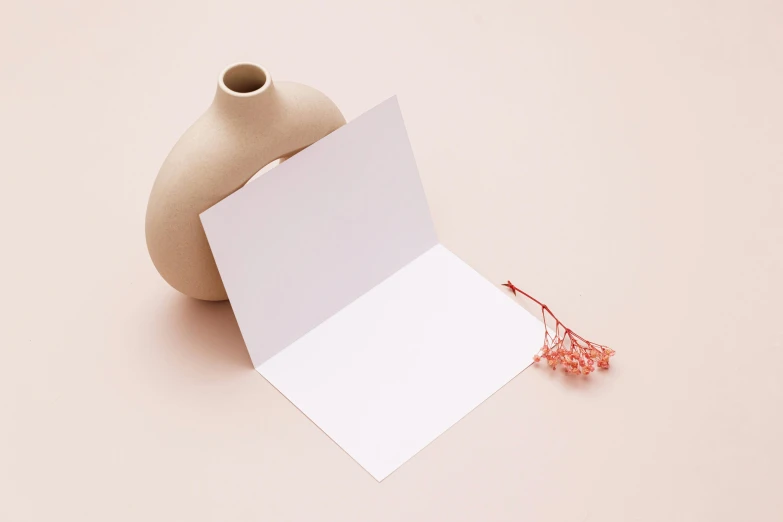 a piece of paper, some white cards and a brown vase