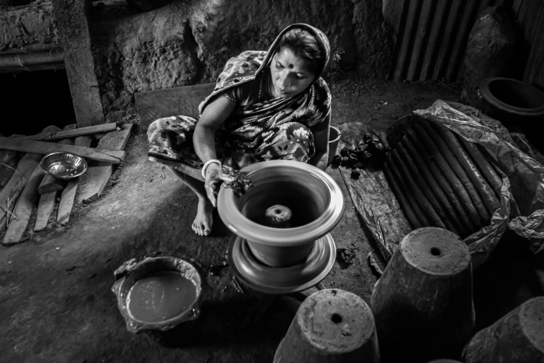 a woman sitting on the floor next to pots