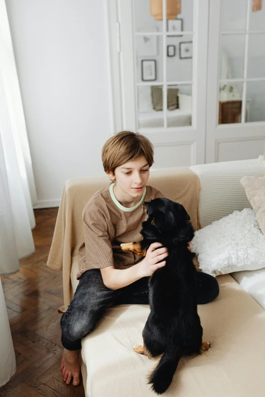 a boy with his dog sitting on the sofa