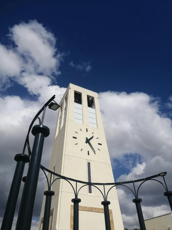 a white clock tower sitting on the side of a road