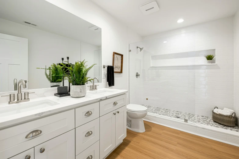 a bathroom with wooden floors, a sink and large mirror