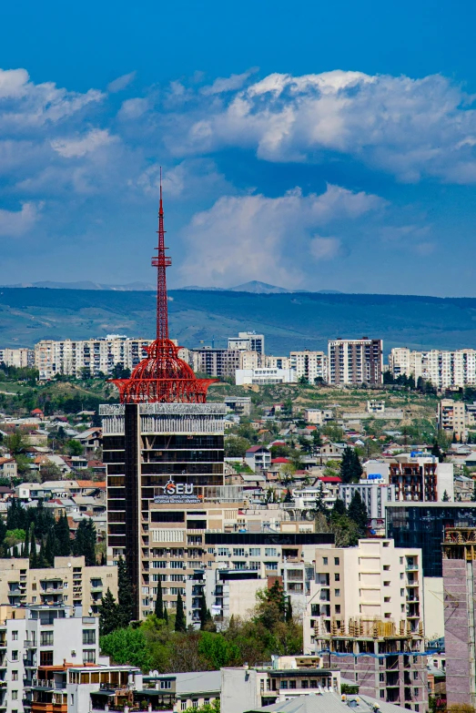 a red tower that is next to a group of tall buildings