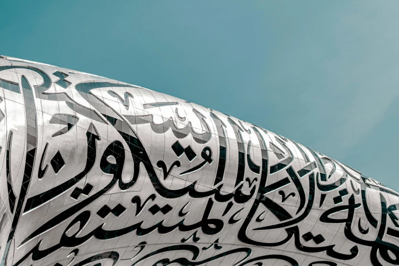 an intricate white metal structure with writing in arabic