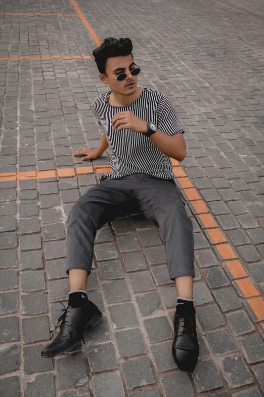 a person is laying on the brick floor wearing a black hat