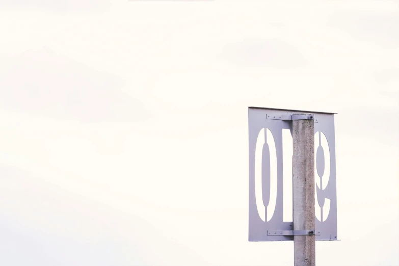 a pole holding a large number sign with a blue sky in the background