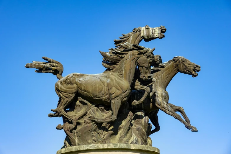 there are some horses that have crashed at the base of this statue