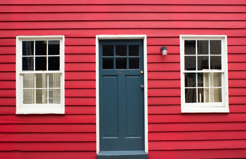 a red house with two windows and blue door