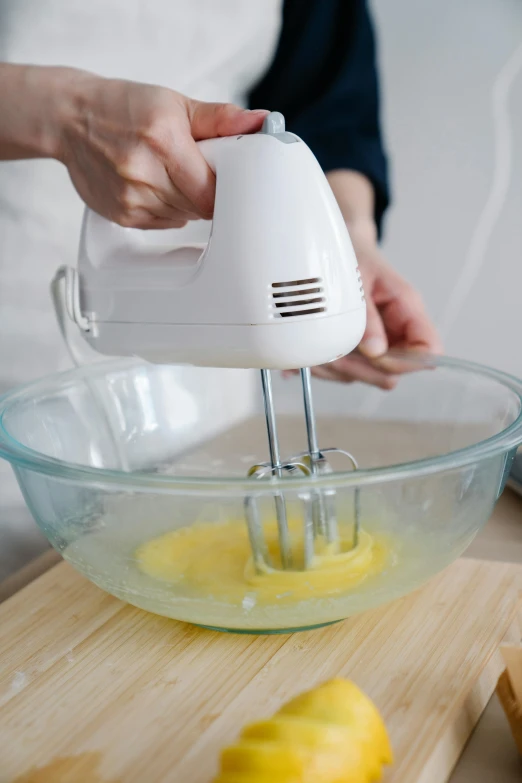 someone mixes an egg mixture with a hand mixer