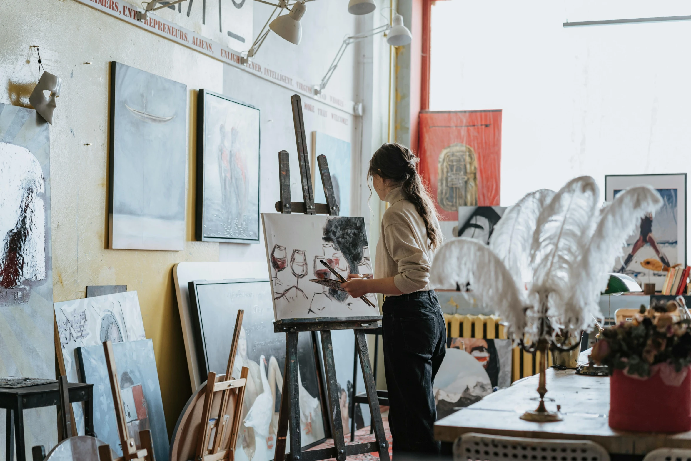 a woman standing next to a table with a painting