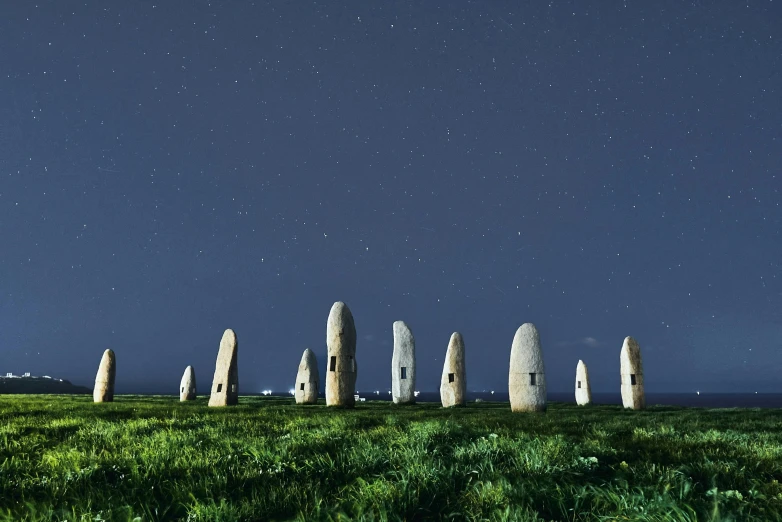 the view of some very tall rocks with green grass on each