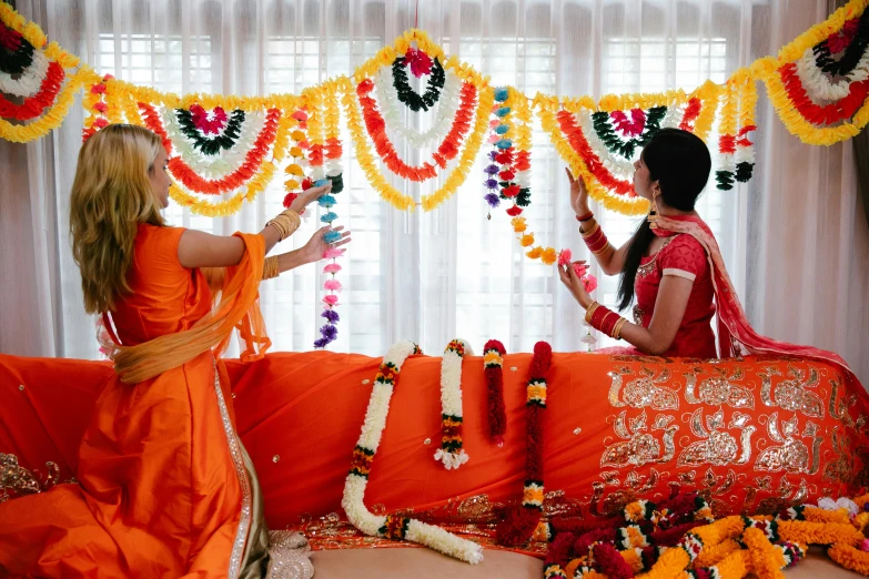 two women working on a decorated garland at a wedding