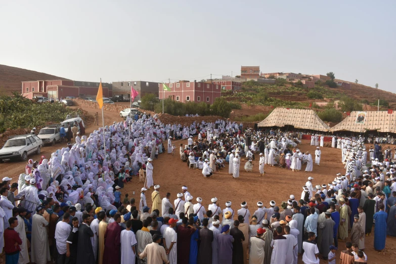 an overhead view of a crowd of people on a dirt field