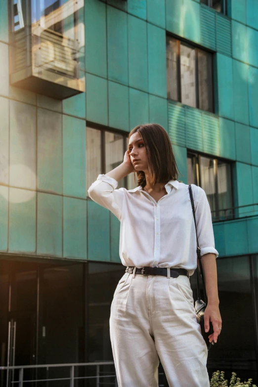 a woman standing on a street talking on a cell phone