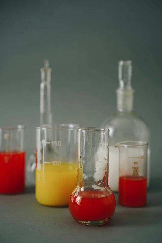 a table topped with three different colored liquids