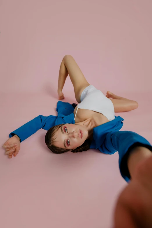 a woman in a blue and white shirt laying on the ground