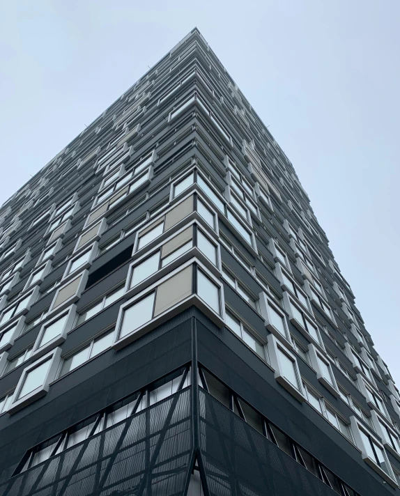 a tall building with many windows and sky in the background