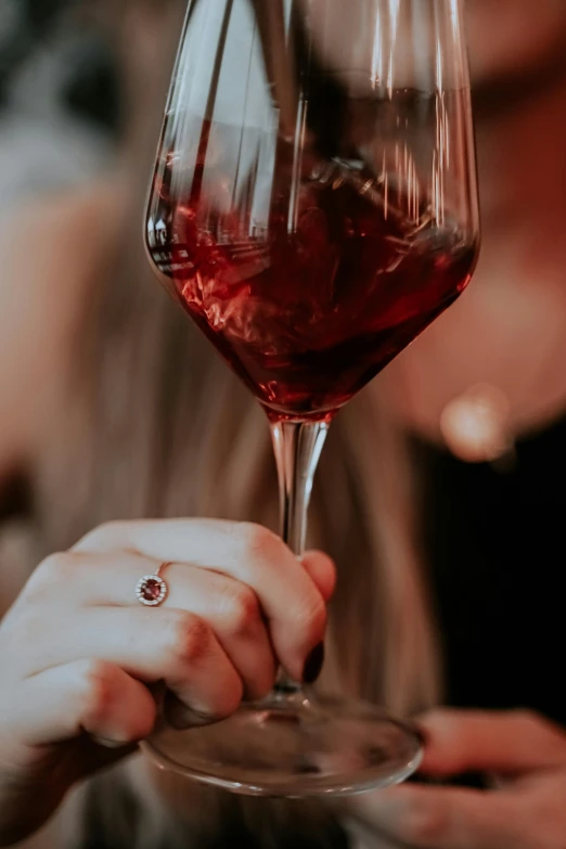 a hand holding a glass of red wine