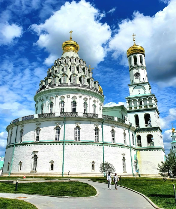 the domes and arches of a white building with golden trim