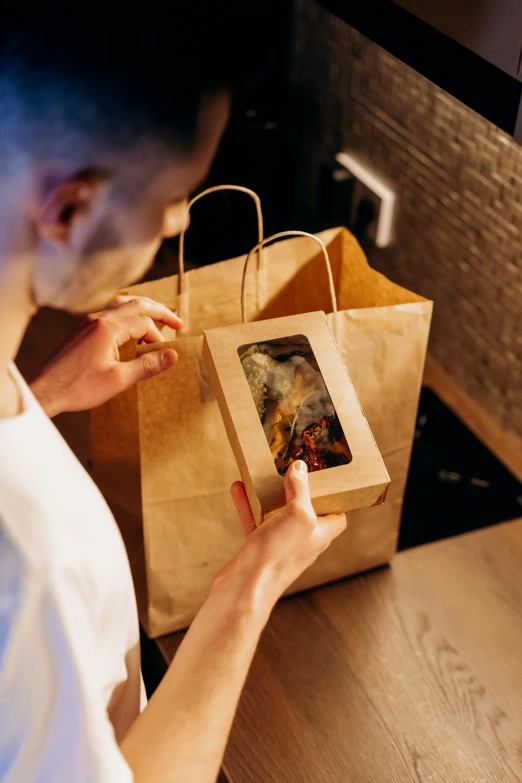 there is a man looking inside the brown paper bag